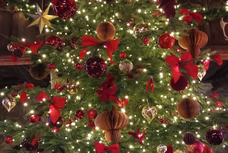 Red and gold decorations on a real Christmas tree